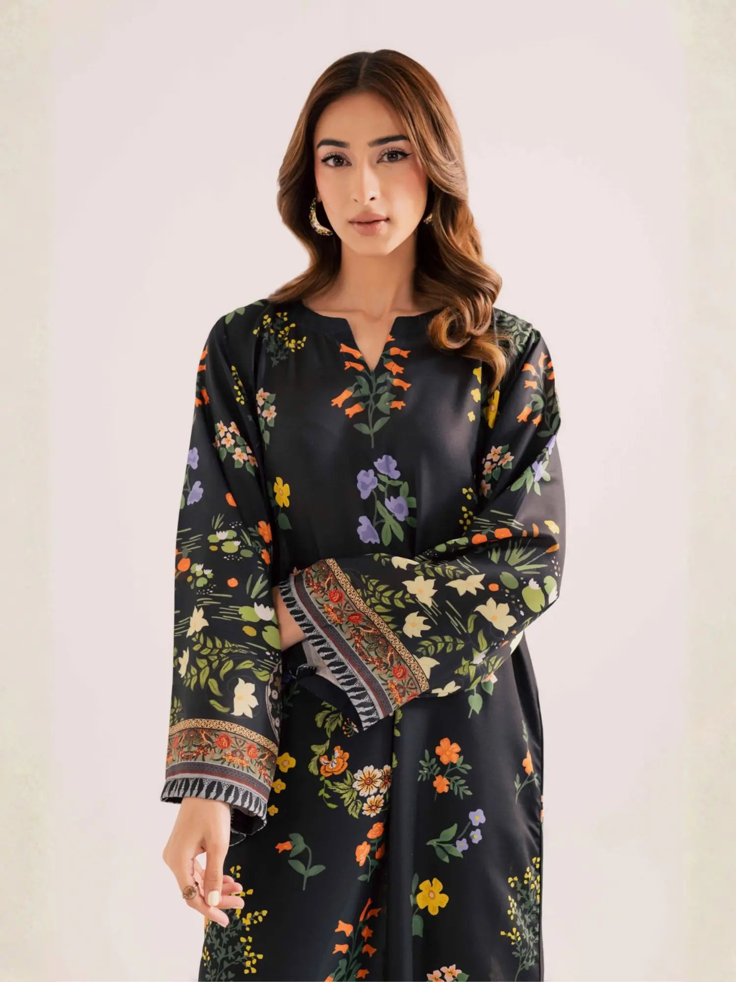 Woman wearing a dark floral dress with a plain background
