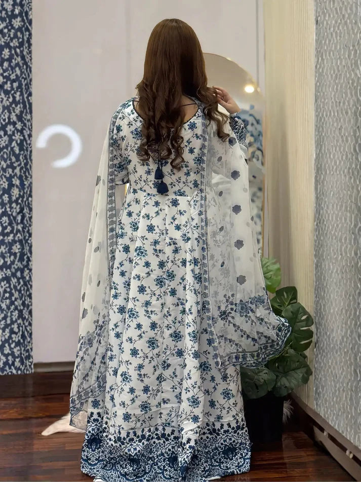 Woman wearing a blue and white floral dress standing in front of a mirror.