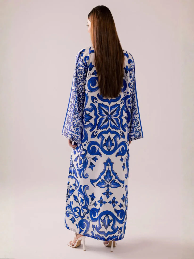 Woman wearing a blue and white patterned dress against a plain background