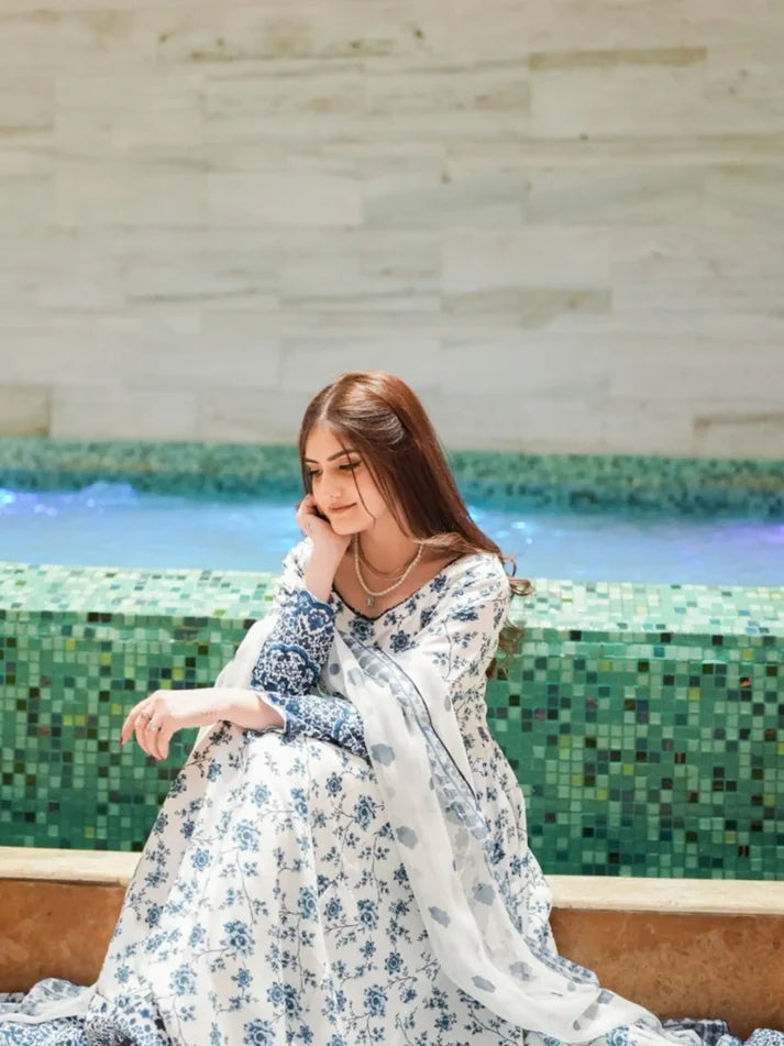 Woman in a floral dress sitting by a fountain