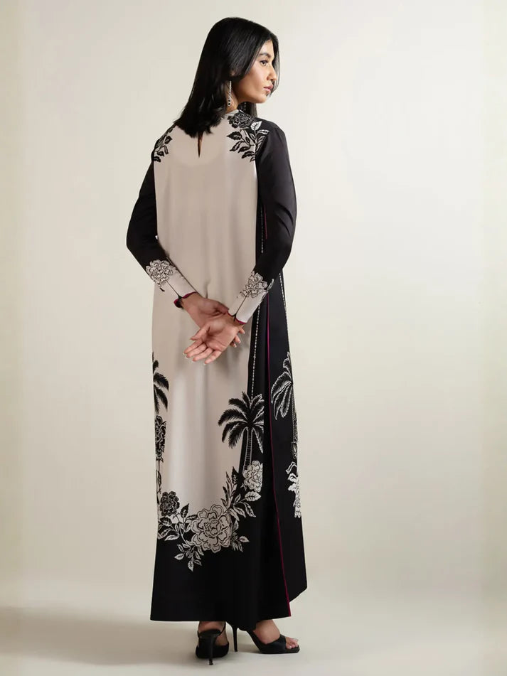 Woman wearing a black and white floral embroidered dress on a plain background