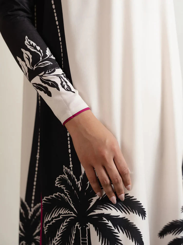 Close-up of a person wearing a black and white patterned garment with a plain background