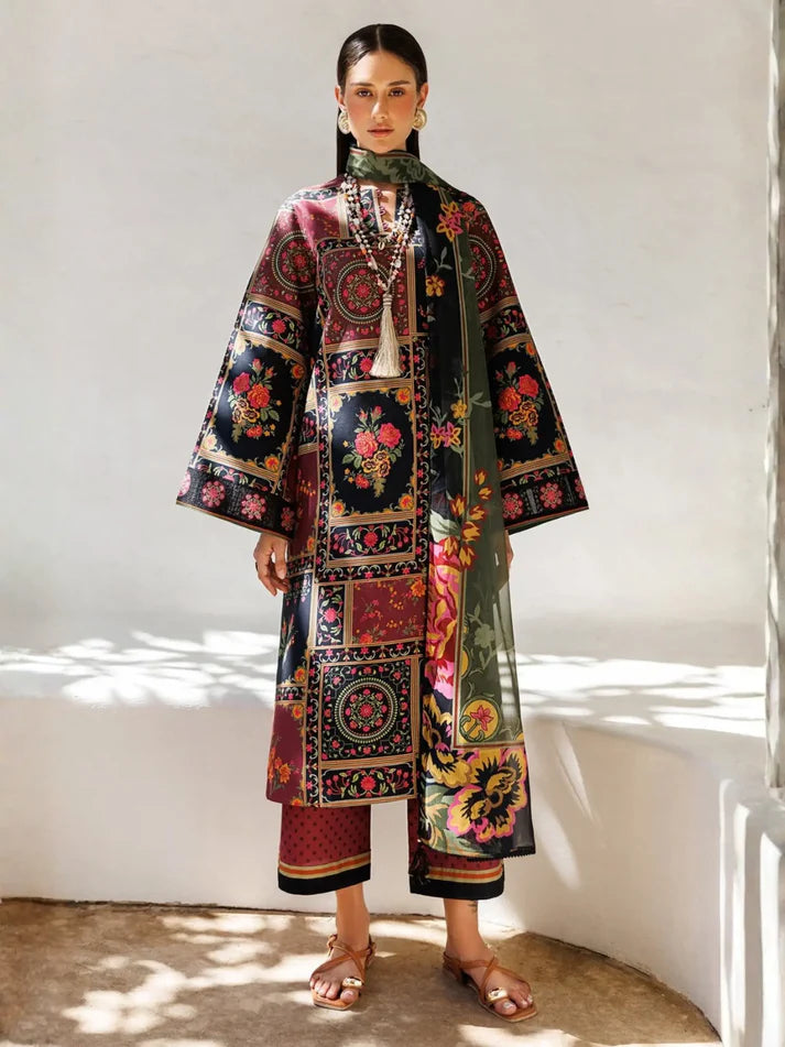 A woman models a traditional Indian outfit consisting of a multicolor patchwork kurta with wide sleeves, matching cropped trousers, and a green patterned scarf, set against a white wall with soft shadows.