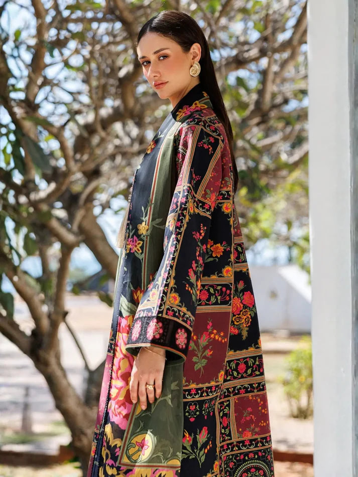A woman wearing a long-sleeved, high-neck maxi dress with a multicolor patchwork floral print, standing outdoors in front of trees.