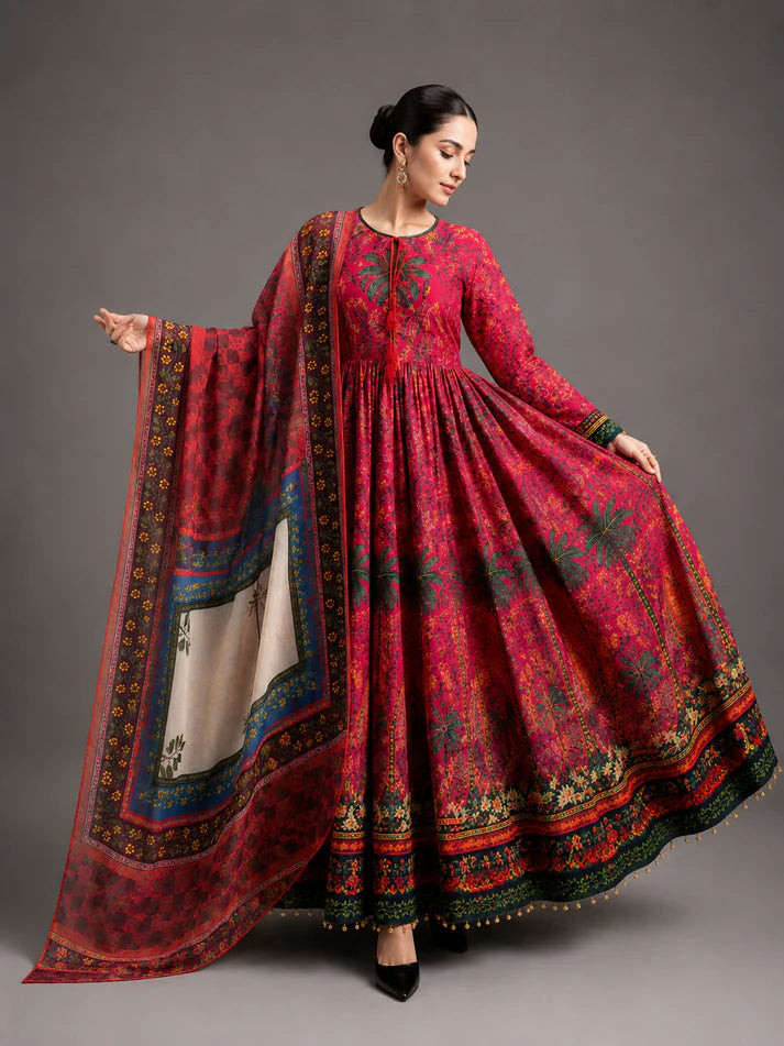 Woman wearing a red traditional outfit with a patterned dupatta against a gray background