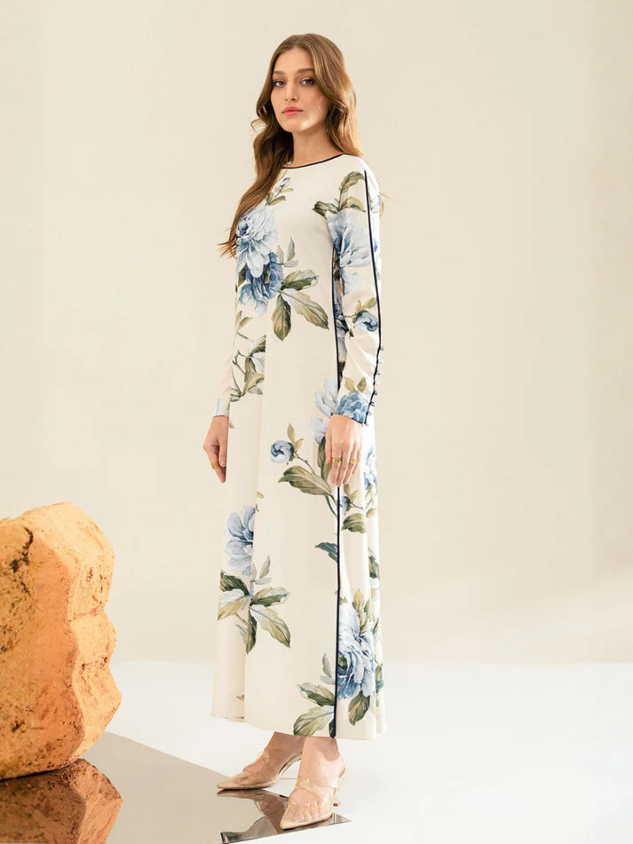Woman wearing a floral dress standing next to a rock on a neutral background