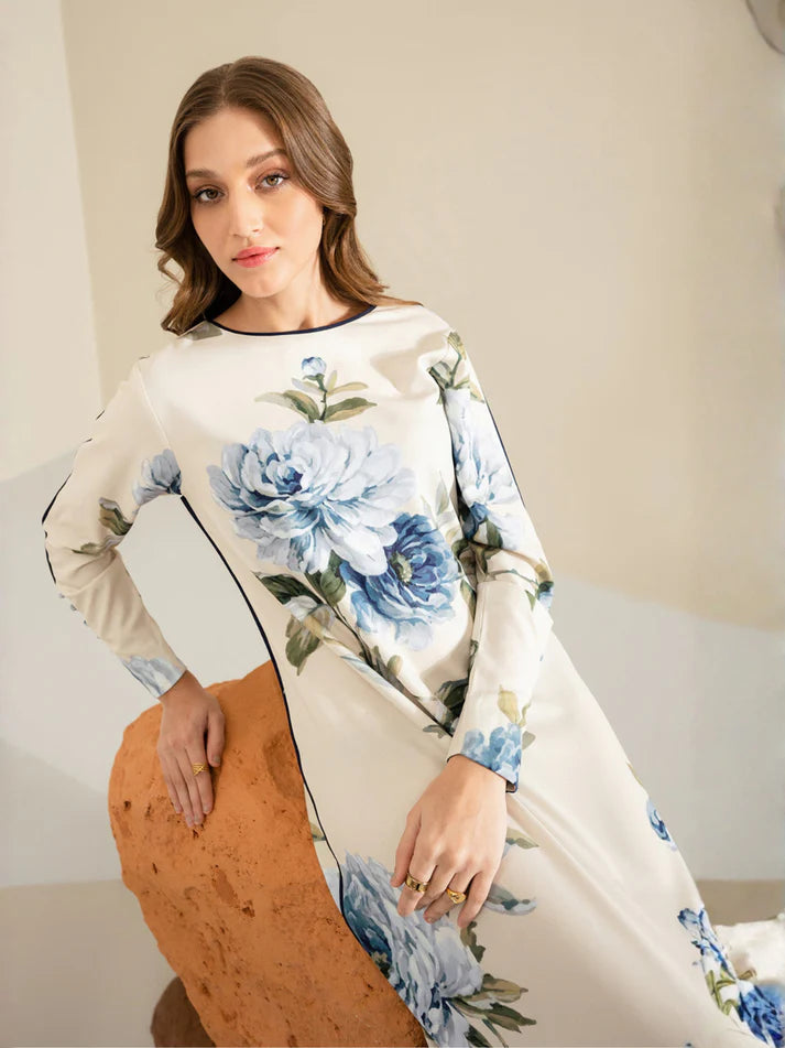 Woman wearing a floral dress sitting on a couch.