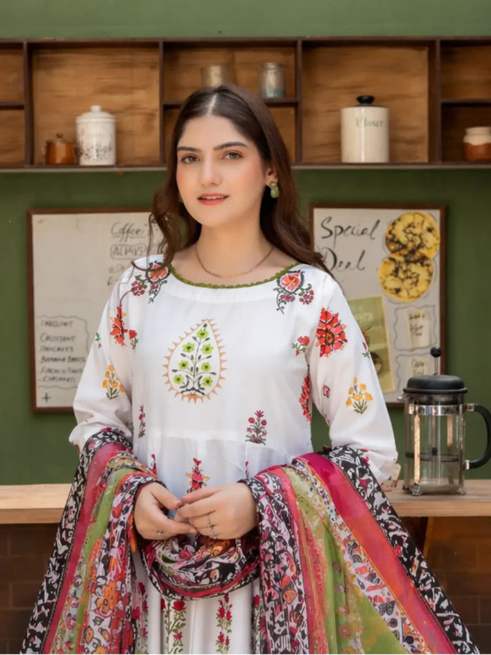 Woman in a colorful traditional outfit sitting in a classroom setting.